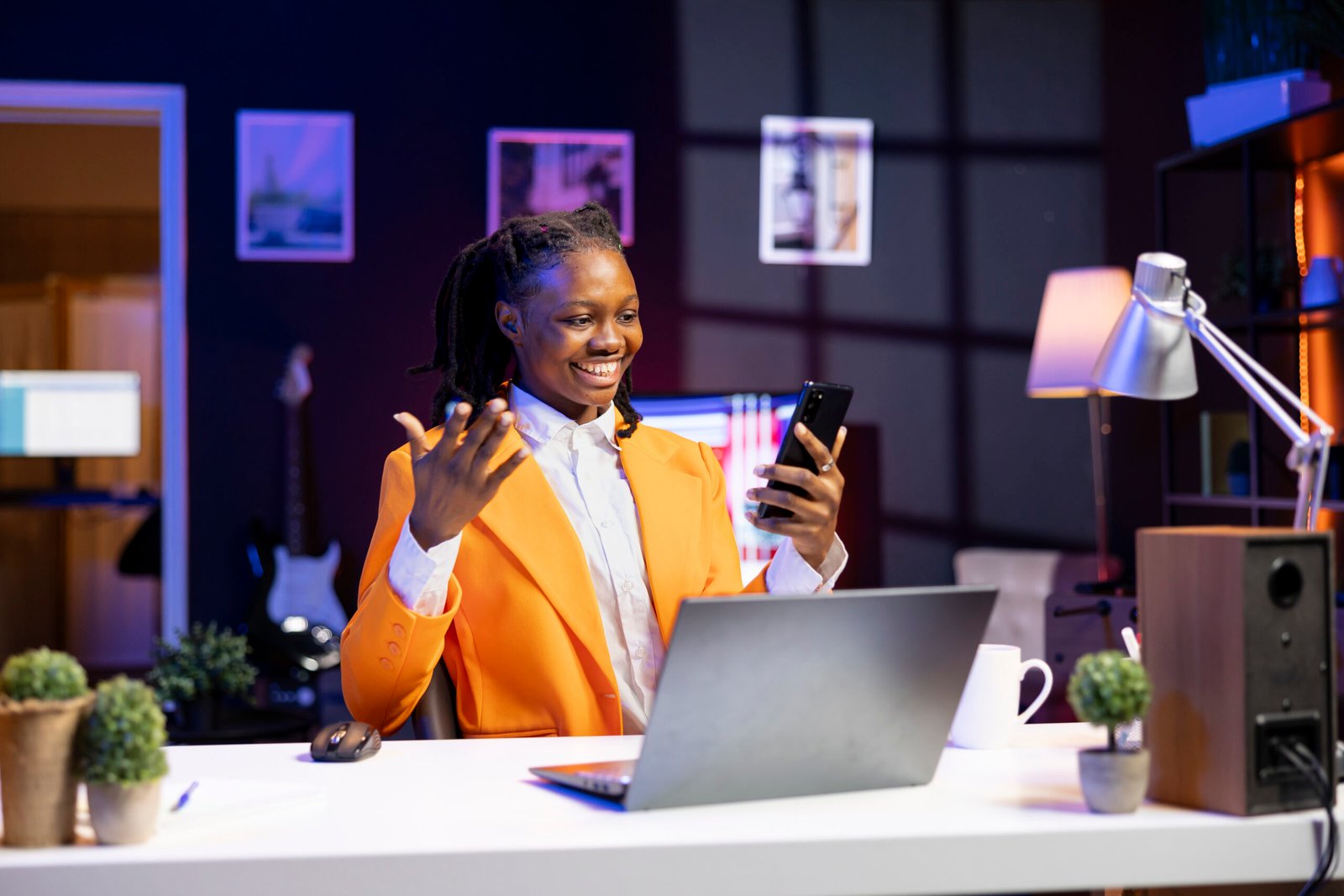 African american woman relaxing in apartment, texting friends on cellphone, enjoying leisure time. Smiling remote worker taking break to talk with mates on internet using phone